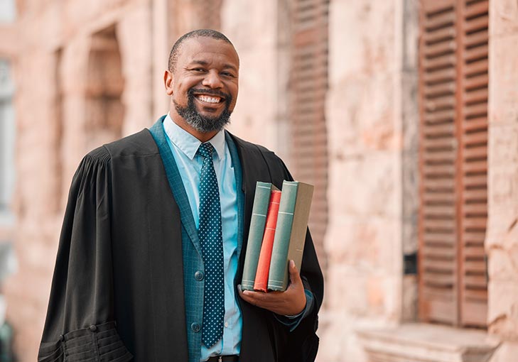 A PhD graduate in ceremonial robes celebrating the culmination of the doctoral journey in the UK.